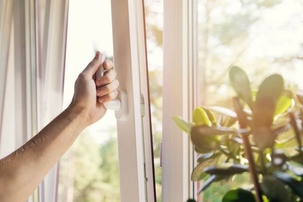 A person opening a window